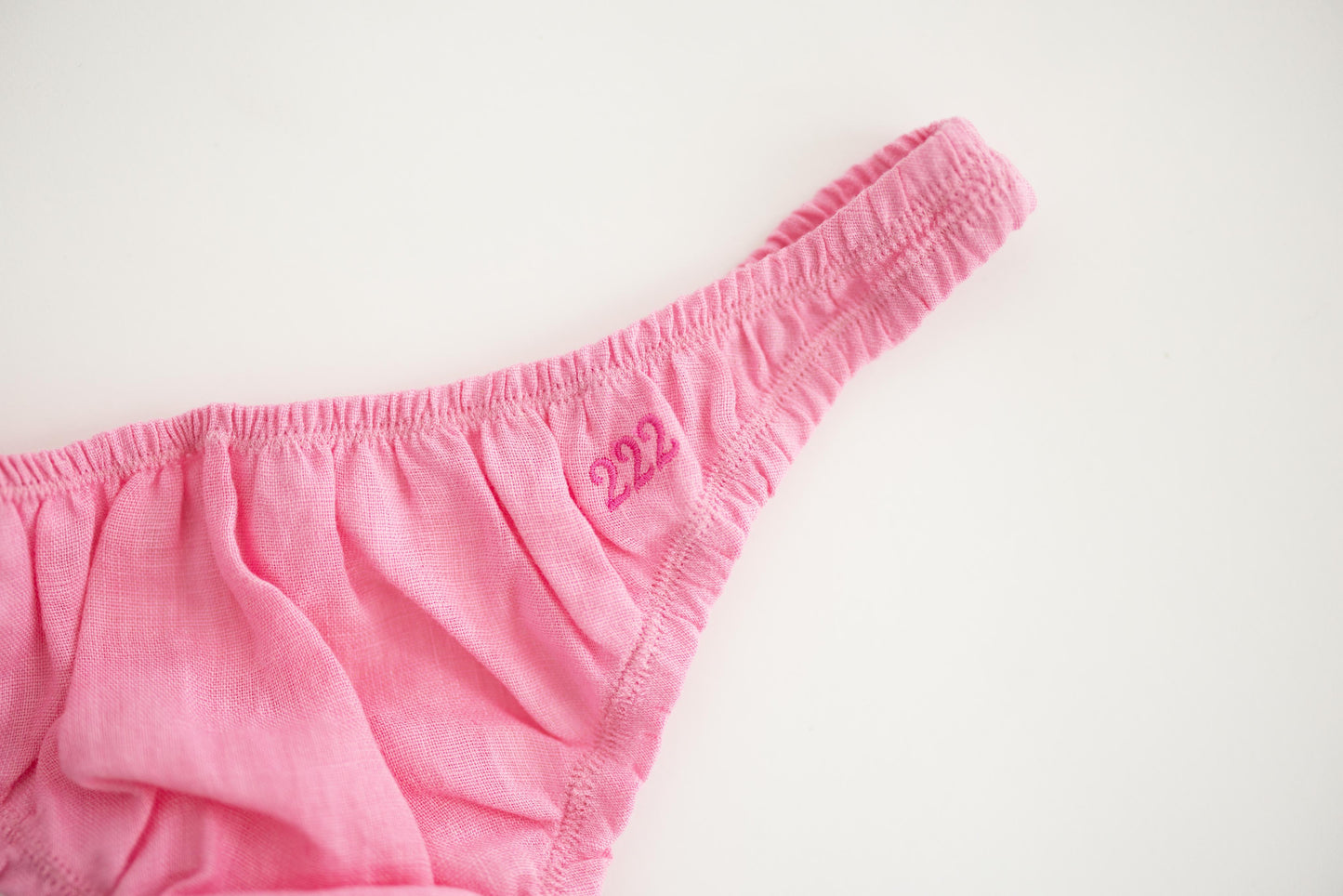 Pink linen thong on a light gray background