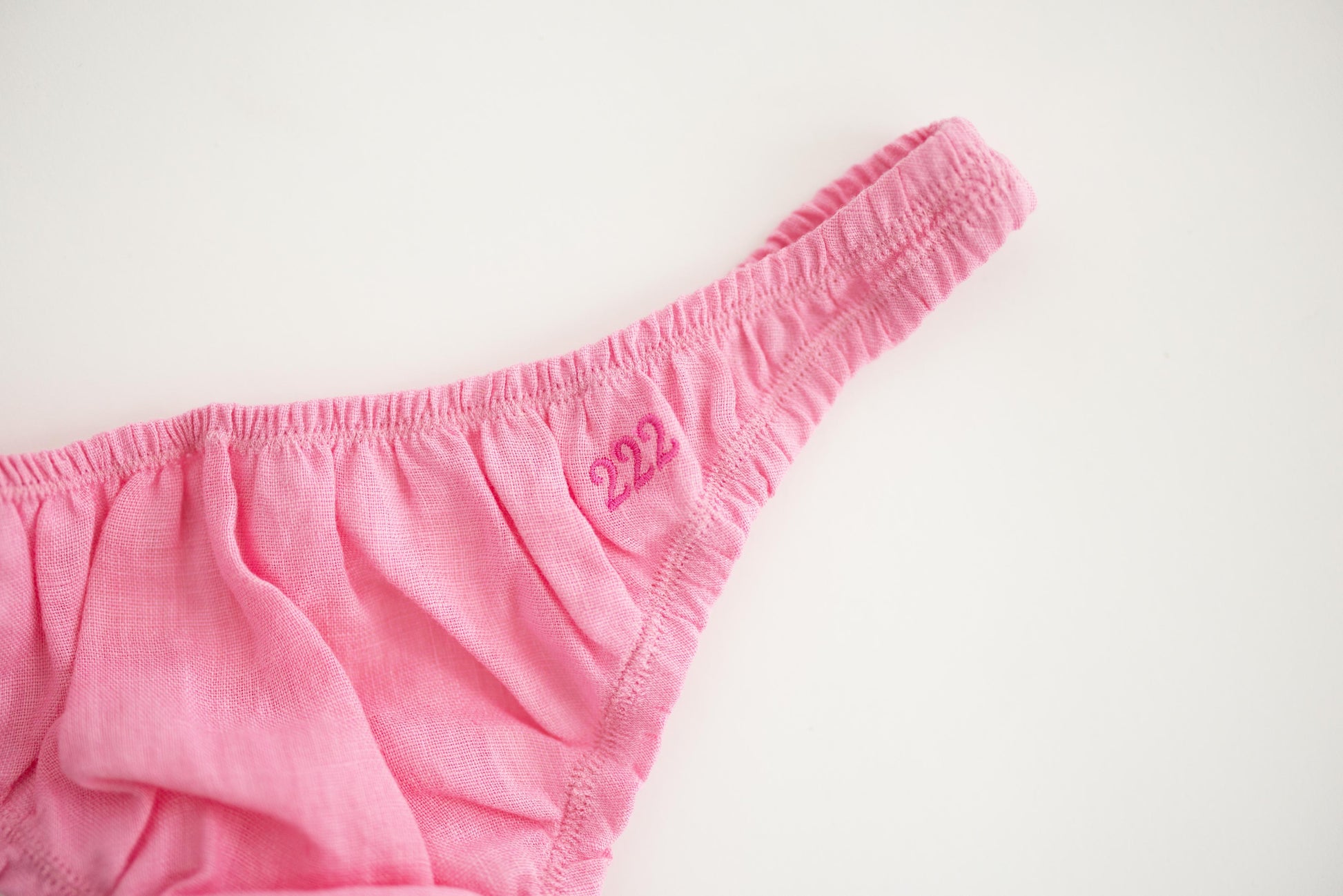 Pink linen thong on a light gray background